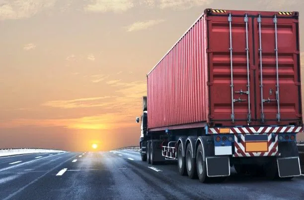 Camión transportando un contenedor al atardecer